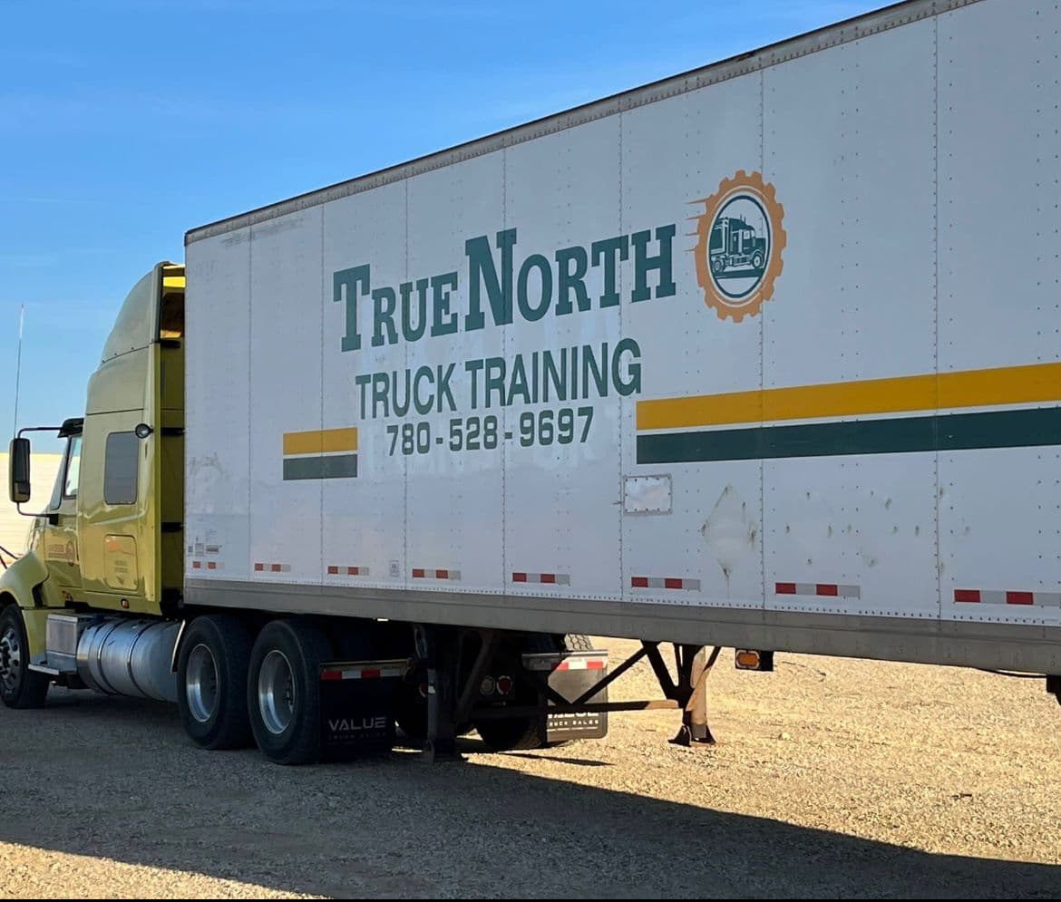 True North Truck Training trailer with branding, phone number, and logo in a gravel lot